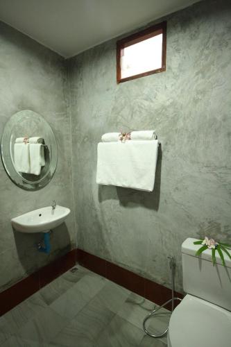 a bathroom with a sink and a toilet and a mirror at Bida Daree Resort in Ao Nang Beach