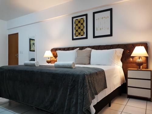 um quarto com uma cama grande e 2 candeeiros em B & A Suites Inn Hotel - Quarto Luxo Âmbar em Anápolis