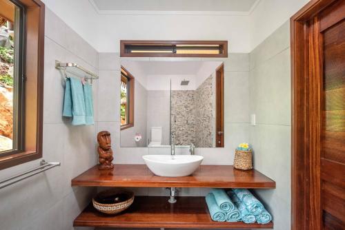 a bathroom with a sink and a mirror at Rainbow Villas in Rarotonga