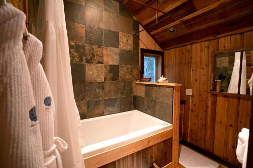 a bathroom with a bath tub in a cabin at Logden Lodge in Nelson