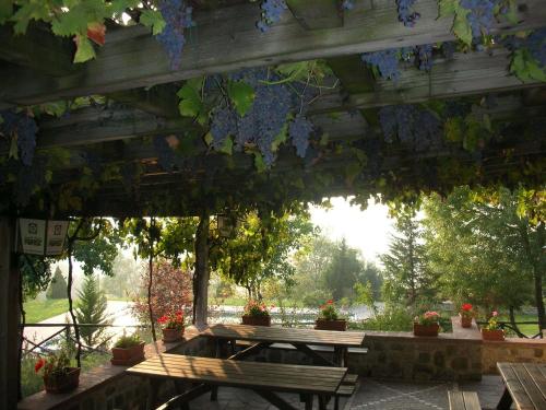 a wooden pergola with a picnic table and benches at Albergo Pian del Bosco in Novafeltria