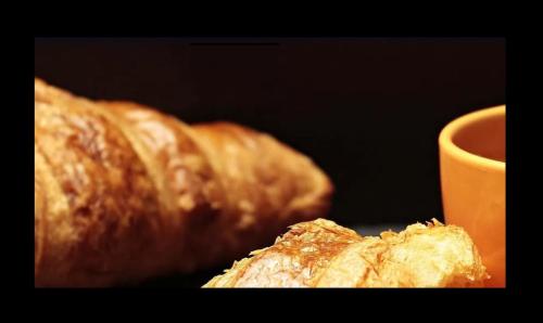a couple of croissants sitting next to a cup of coffee at Metro Inn Ryde in Sydney