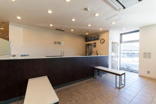 uma grande cozinha com um balcão e uma mesa em Hotel Econo Taki em Ōka