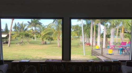 a view of a park with palm trees from a window at Auberge de Poé in Bourail