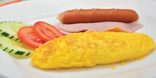 ein Teller mit einem Hotdog und einem Sandwich und Tomaten in der Unterkunft Bida Daree Resort in Ao Nang Beach