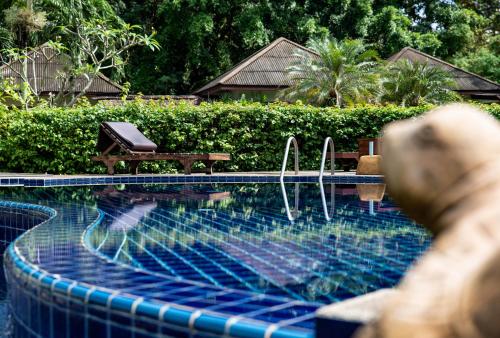 una persona sdraiata accanto a una piscina di Anahata Resort a Lipa Noi