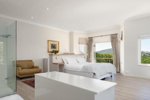a white bedroom with a bed and a window at 4 Piet Retief in Stellenbosch