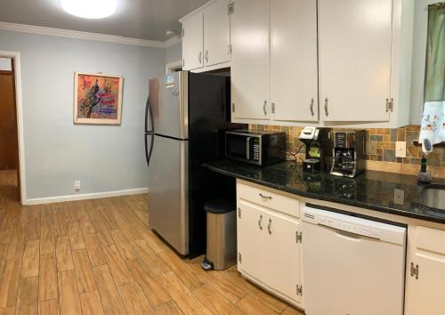 a kitchen with white cabinets and a stainless steel refrigerator at The Peacock House in San Antonio