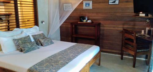 a bedroom with a bed and a desk and a chair at Idylle Beach in Sainte Marie