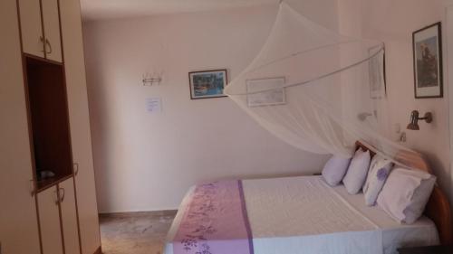a bedroom with a bed with a net over it at Melina's Sunset in Myrties