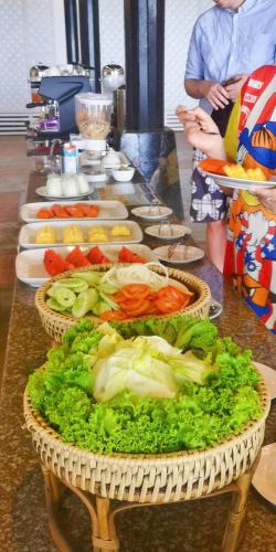 a long table with baskets of vegetables on it at Koh Mak Resort in Ko Mak