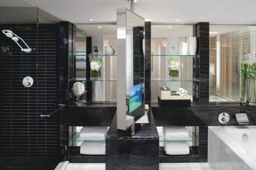 a bathroom with a tv and a tub and a sink at Mandarin Oriental Hong Kong in Hong Kong