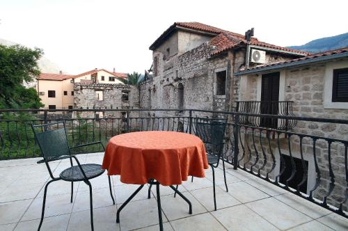 a table and chairs on the balcony of a building at Panonija in Kotor