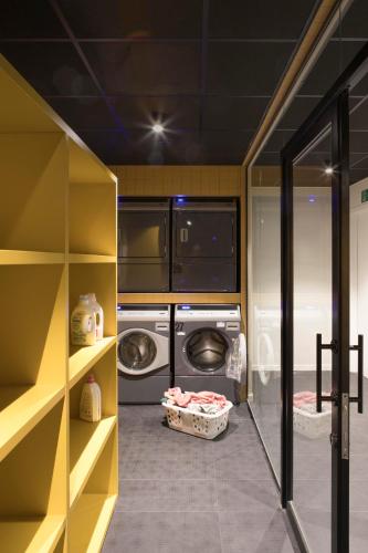 a laundry room with a washer and dryer at ROXI The Urban Residence Brussels in Brussels