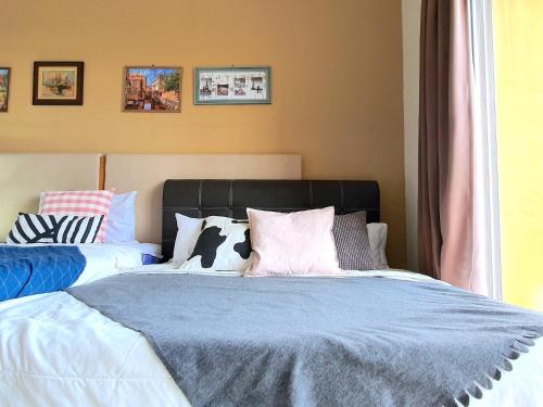a bedroom with a bed with pillows on it at Gold Coast Morib Themepark View Studio in Banting