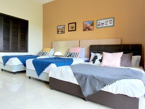 a bedroom with three beds with blue and white sheets at Gold Coast Morib Themepark View Studio in Banting