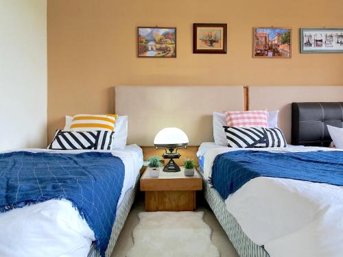 two beds sitting next to each other in a room at Gold Coast Morib Themepark View Studio in Banting