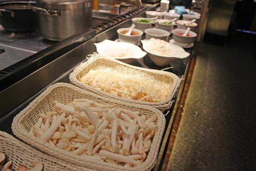 a buffet line with baskets of food on a table at Ramada Changzhou North Hotel in Changzhou