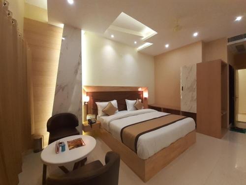 Habitación de hotel con cama, mesa y silla en Hotel Bharat en Kota