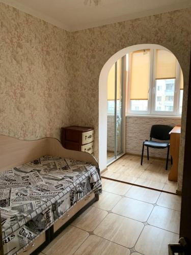 ein Schlafzimmer mit einem Bett, einem Stuhl und einem Fenster in der Unterkunft 131 проспект Добровольского Хорошая 3-х комнатная квартира в Одессе in Odessa