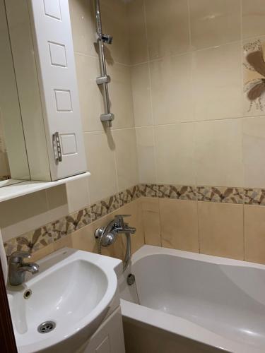 ein Badezimmer mit einem Waschbecken und einer Badewanne in der Unterkunft 131 проспект Добровольского Хорошая 3-х комнатная квартира в Одессе in Odessa