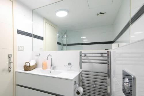 a white bathroom with a sink and a mirror at 104 - King David Residence - Jerusalem-Rent in Jerusalem