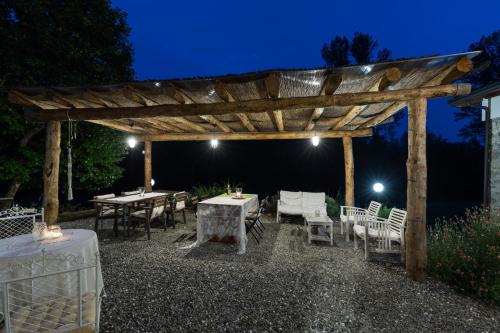 a wooden pergola with tables and chairs at night at Agriturismo di là dall'Acqua in Fivizzano