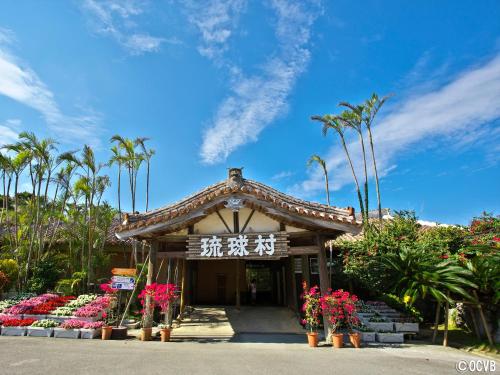 a small building with flowers in front of it at Yomitan Condhotel ND in Yomitan
