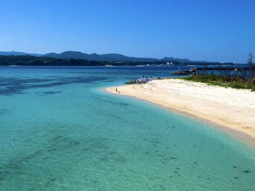a beach with turquoise water and a sandy shore at Yomitan Condhotel ND in Yomitan