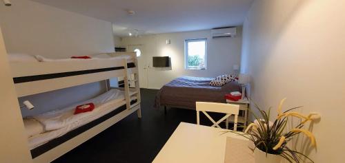 Zimmer mit 2 Etagenbetten und einem Tisch in der Unterkunft Söderåsens Golf Lodge in Risekatslösa