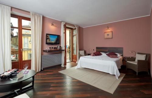 a bedroom with a large white bed and a table at Casa Svizzera Agriturismo in Barolo