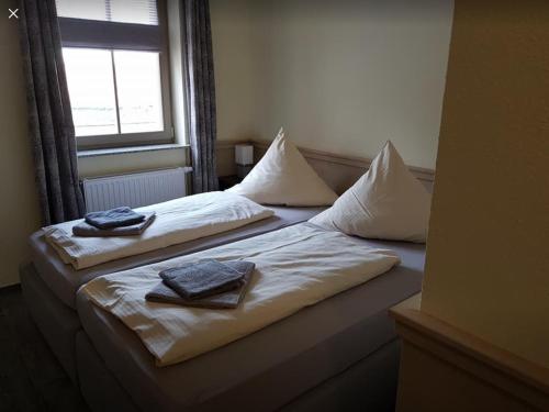 two beds in a room with towels on them at Pension Gasthaus Zur Forelle in Seeburg