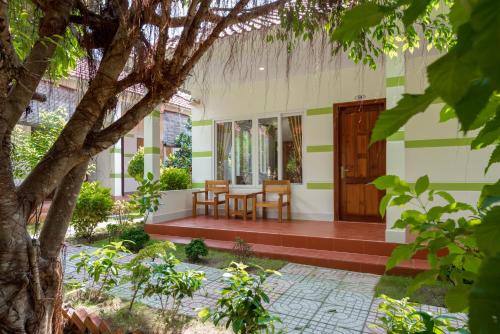 a porch of a house with a table and chairs at Trung Huynh Bungalow in Phu Quoc