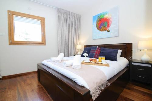 a bedroom with a large bed with a tray of food on it at 108 - King David Residence - Jerusalem-Rent in Jerusalem