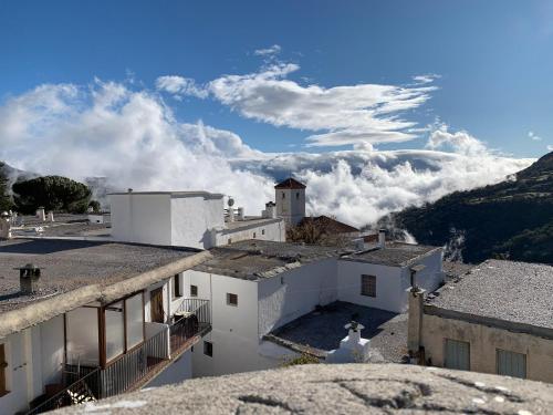 vistas a las montañas desde los tejados de los edificios en Hotel Rural Alfajía de Antonio en Capileira