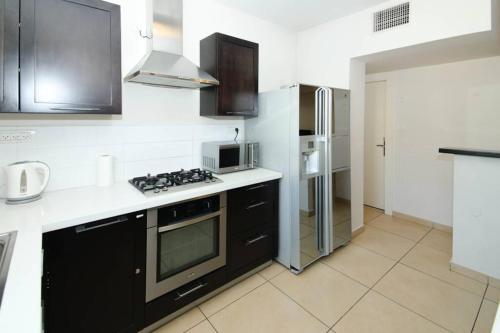 a kitchen with a stove and a refrigerator at 202 - King David Residence - Jerusalem-Rent in Jerusalem