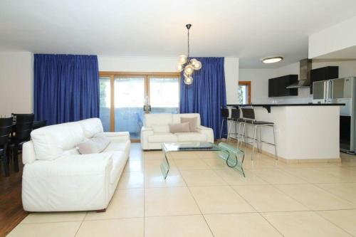a living room with two white couches and a kitchen at 202 - King David Residence - Jerusalem-Rent in Jerusalem