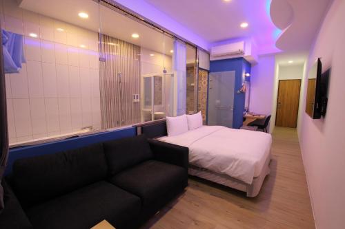 ein Hotelzimmer mit einem Bett und einem Sofa in der Unterkunft Lang Qin B&B in Nanwan