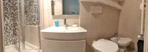 a white bathroom with a sink and a toilet at Flat House in Fiumicino
