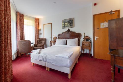a bedroom with a large bed with a wooden headboard at Amsterdam Wiechmann Hotel in Amsterdam