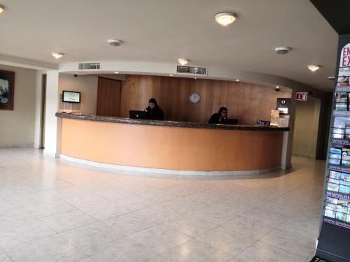 a lobby with two people sitting at a counter at Hotel Son- Mar Monterrey Centro in Monterrey