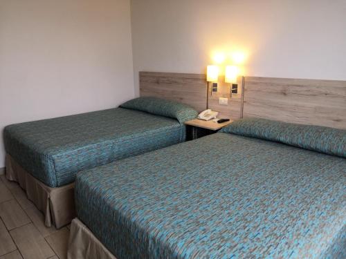 a hotel room with two beds and a telephone at Hotel Son- Mar Monterrey Centro in Monterrey