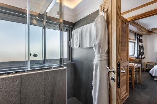 a bathroom with a shower and a glass door at Hotel Annapurna in Courchevel