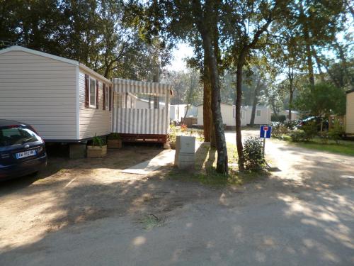 a house with a car parked next to a tree at HOME-COSY - 6 pers - 40 m2 3 CH - 2 SDB et 2 WC in Saint-Brevin-les-Pins