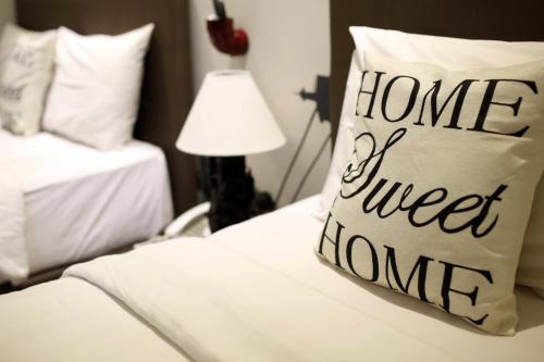a bed with a pillow that reads home sweet home at Shine BnB in Tjiandjur