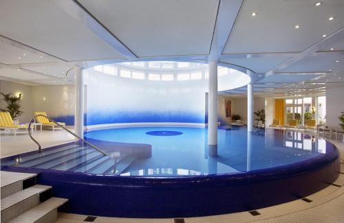 a large blue and white swimming pool in a building at Colombi Hotel in Freiburg im Breisgau