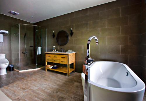 ein Bad mit einer Badewanne, einer Dusche und einem Waschbecken in der Unterkunft Villa 88 in Fengping