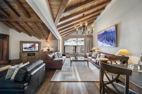 a living room with leather furniture and a wooden ceiling at Hotel Annapurna in Courchevel