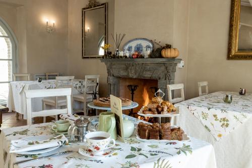 a room with a table with pastries and a fireplace at Casanova di Neri Relais in Montalcino