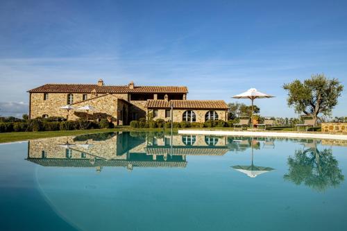 a large pool of water in front of a house at Casanova di Neri Relais in Montalcino